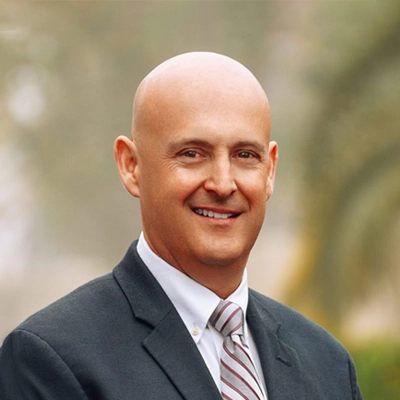 Dr. Christopher Berry smiling in a suit.